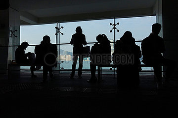 Hong Kong  China  Silhouette: Menschen warten im Terminal der Star Ferry auf ihre Faehre