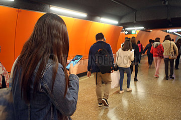Hong Kong  China  Frau tippt beim Laufen durch einen Tunnel auf ihrem Smartphone herum