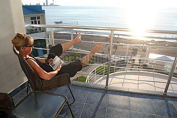 Batumi  Georgien  Frau sitzt auf dem Balkon eines Hotels und liest ein Buch