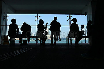 Hong Kong  China  Silhouette: Menschen warten im Terminal der Star Ferry auf ihre Faehre
