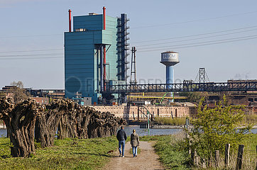 Industrielandschaft im Ruhrgebiet  Spaziergaenger spazieren am Rhein vor Industriekulisse HKM  Duisburg  Nordrhein-Westfalen  Deutschland  Europa