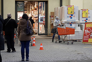 Berlin  Deutschland  Menschen stehen in Zeiten der Coronapandemie vor einem Baumarkt an