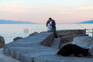 Kroatien  Volosko - Paar auf der Kaimauer am Hafen des Fischerdorfs Volosko an der Adria (Kvarner Bucht)