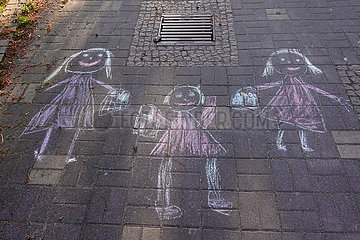 Berlin  Deutschland  Kreidezeichnung dreier Maedchen auf Asphalt