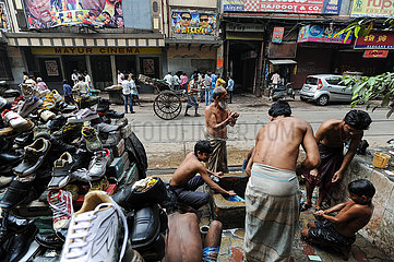 Kalkutta  Indien  Maenner waschen sich an einem kommunalen Waschplatz auf der Strasse waehrend eine Rikscha vorbeizieht
