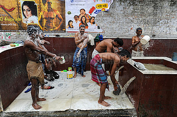 Kalkutta  Indien  Eine Gruppe Maenner waescht sich an einem kommunalen Waschplatz auf der Strasse