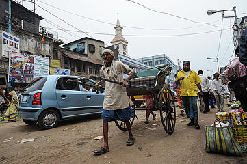 Kalkutta  Indien  Alltaegliche Strassenszene mit einem Rikschalaeufer in der indischen Metropole