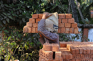 Yangon  Myanmar  Bauarbeiter traegt Ziegelsteine zu einer benachbarten Baustelle