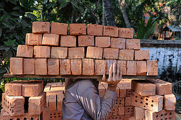 Yangon  Myanmar  Bauarbeiter traegt Ziegelsteine zu einer benachbarten Baustelle