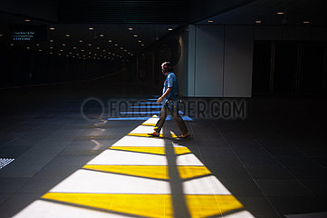 Singapur  Republik Singapur  Mann mit Mundschutz in Unterfuehrung an der Expo MRT Metro Haltestelle