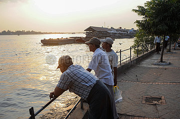 Yangon  Myanmar  Einheimische stehen am Ufer des Yangon River in der Abendsonne