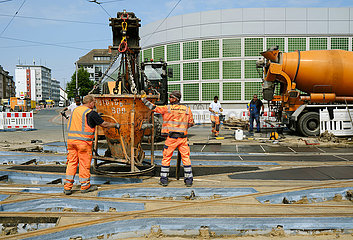 Deutschland  Bremen - Bauarbeiter verteilen Spezialbeton zwischen den neuen Strassenbahnschienen