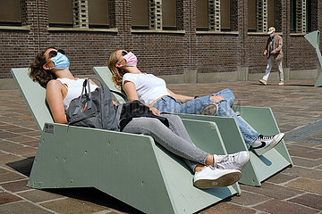 Deutschland  Bremen - zwei junge Frauen mit Atemschutzmasken Frauen sonnen sich in der Innenstadt