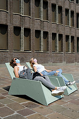 Deutschland  Bremen - zwei junge Frauen mit Atemschutzmasken Frauen sonnen sich in der Innenstadt