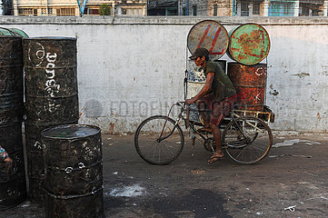 Yangon  Myanmar  Rikschafahrer transportiert leere rostige Faesser auf seiner Fahrrad-Rikscha