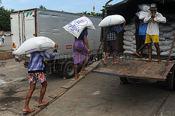 Yangon  Myanmar  Arbeiter laden Saecke gefuellt mit Reis auf einen LKW am Hafen