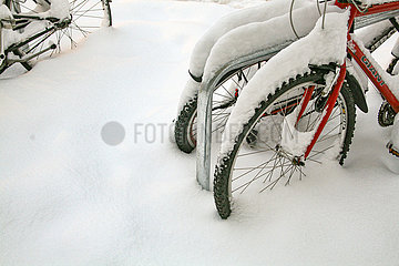 Im Schnee abgestellte Fahrräder