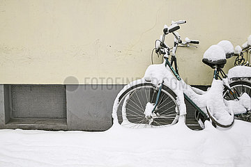 Im Schnee abgestellte Fahrräder