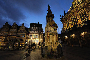 Deutschland  Bremen - Der Roland  ein Wahrzeichen der Hansestadt in der Abenddaemmerung auf dem Marktplatz  rechts das historische Rathaus