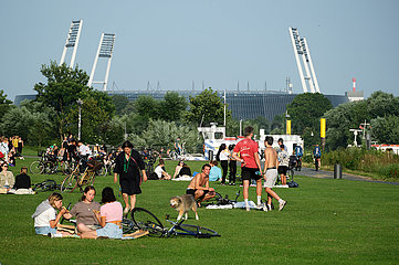 Deutschland  Bremen - Menschen geniessen den Sommer am Osterdeich an der Weser  hinten das Weserstadion des SV Werder Bremen
