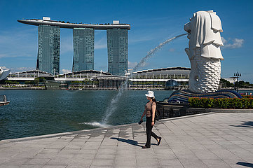 Singapur  Republik Singapur  Frau mit Mundschutz im Merlion Park in Marina Bay waehrend Corona-Krise