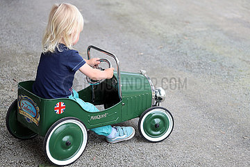 Hannover  Deutschland  Kleinkind sitzt in einem Kinderauto