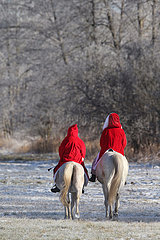 Bruchmuehle  Deutschland  Weihnachtsmaenner reiten auf ihren Pferden durch die Natur
