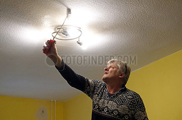 Berlin  Deutschland  Mann streicht in seiner Wohnung eine Zimmerdecke