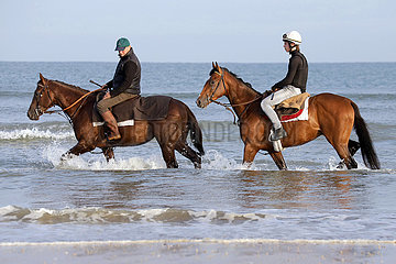 Deauville  Reiter kuehlen die Beine ihrer Pferde im Wasser des Atlantiks