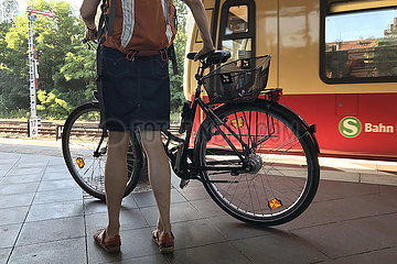 Berlin  Deutschland  Frau steht mit ihrem Fahrrad auf einem S-Bahnhof
