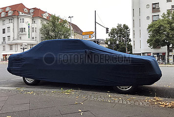 Berlin  Deutschland  Auto mit Schutzbezug parkt am Strassenrand