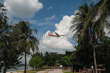 Singapur  Republik Singapur  Frachtflugzeug fliegt ueber den Changi Beach Park bevor es auf dem Flughafen Changi landet