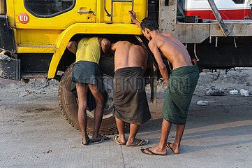Yangon  Myanmar  Junge Arbeiter inspizieren einen defekten LKW am Strassenrand