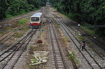 Yangon  Myanmar  Zug und Fussgaenger auf Bahnschienen im Stadtzentrum
