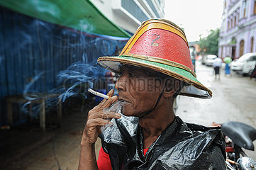 Yangon  Myanmar  Ein Rikschafahrer macht Pause und raucht eine Zigarette