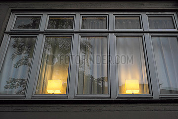Deutschland  Bremen - Zwei gleiche Lampen stehen symmetrisch im Fenster einer Wohnung