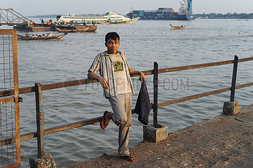 Yangon  Myanmar  Ein Mann steht am Ufer des Yangon River in der Abendsonne