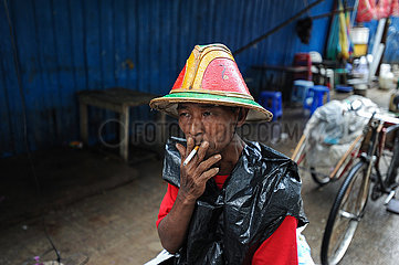 Yangon  Myanmar  Ein Rikschafahrer macht Pause und raucht eine Zigarette