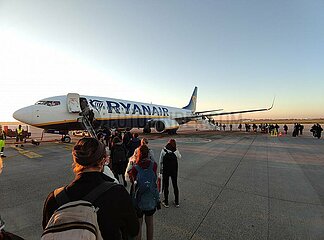 Passagiere laufen ueber das Rollfeld zu einem Ryanair-Flugzeug