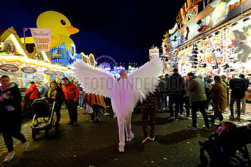 Deutschland  Bremen - Junger Mann mit Engelkostuem auf Bremer Freimarkt. Der beliebte Jahrmarkt ist wegen Corona verkleinert und mit 3-G-Regelung