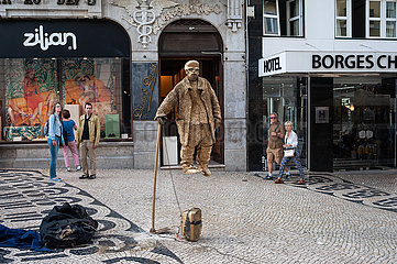 Lissabon  Portugal  Schwebender Strassenkuenstler tritt in Gold gekleidet in einer Fussgaengerzone auf