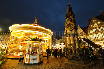 Deutschland  Bremen - Weihnachtsmarkt auf dem Marktplatz mit 2G-Regel  links Karussel  rechts der Roland