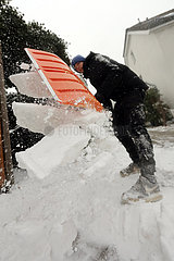 Berlin  Deutschland  Teenager schaufelt frisch gefallenen Schnee vom Gehweg