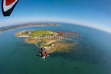 FRANCE. Manche (50) Photographer Jerome Houyvet on a paramotor above Ile Dec  and its cape  north-east of Cotentin located in the bay of Saint-Vaast-la-Hougue