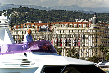 France. Alpes-Maritimes (06)  Cannes  festival de Cannes. Yacht passing in front of the Carlton Palace  decorated with movie posters Gatsby le Magnifique. Film director Baz Luhrmann