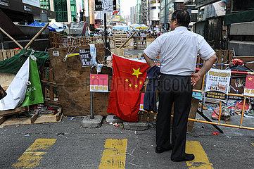 Hongkong  China  Mann vor Barrikade eines Protestcamps im Stadtteil Mong Kok an der eine Chinesische Flagge haengt