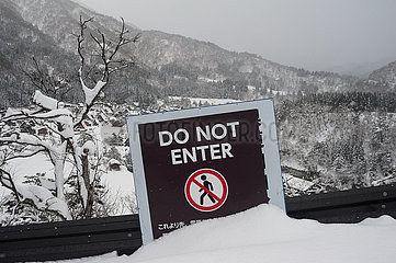 Shirakawa-go  Japan  Verbotsschild mit der Aufschrift 'Do Not Enter' und verschneiter Winterlandschaft im Hintergrund
