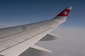 Schweiz  Luftbild im Flug mit Swiss von Zuerich nach Berlin mit Blick aus dem Flugzeug auf Fluegel und Himmel