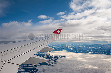 Schweiz  Luftbild im Flug mit Swiss von Zuerich nach Berlin mit Blick aus Flugzeug auf Fluegel und Berglandschaft