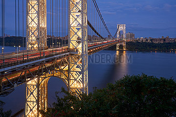 Vereinigte Staaten  New York City  Upper Manhattan. Die beleuchtete George Washington Bridge erstreckt sich an den Hudson River am Abend